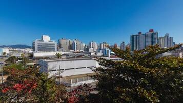 Un paisaje urbano con edificios modernos, incluyendo una estructura blanca destacada con techo plano y un edificio alto de varios pisos con techo rojo.