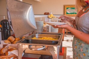 Un buffet avec une plaque de cuisson, des assiettes et un panier de pain.