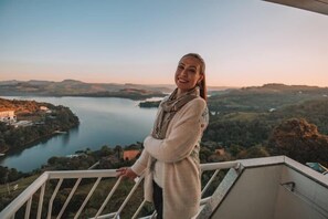 A person standing on a balcony overlooking a lake and hills. - Itá Thermas Resort e Spa (Ita)