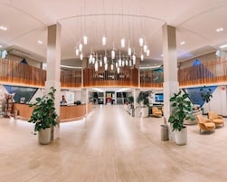Um hall amplo com pé direito alto, iluminação moderna e áreas de estar.
