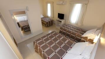 A hotel room with two beds, a TV, and a mirror.