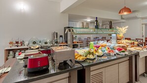 A buffet setup with various food items and a red toaster.