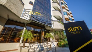A hotel with a modern design, featuring a prominent entrance with glass doors and a staircase leading up to the entrance. - SLIM São José Zion (Sao Jose)