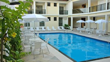 Een buitenzwembad en ligstoelen