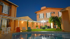 A hotel with a swimming pool, outdoor seating, and a well-lit patio area. - Hotel Terra do Sol (Aracaju)