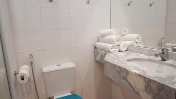 Un baño con inodoro, lavabo y ducha.
