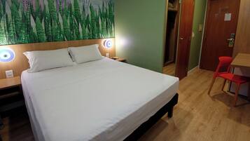 Minibar, escritorio, cortinas blackout y tabla de planchar con plancha