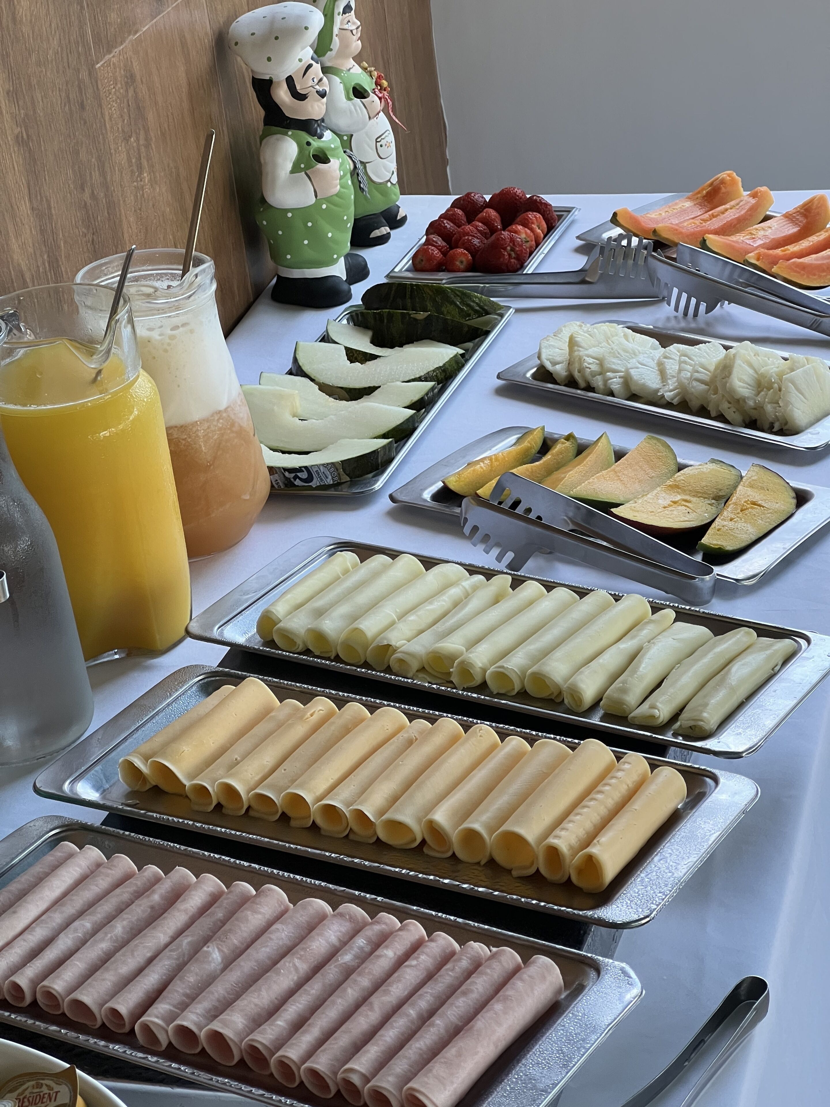 A buffet table with various food items and drinks.
