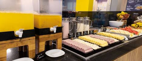 A buffet area with various food options and beverage dispensers.