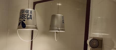 Un baño con un espejo grande, un lavamanos y un perchero para toallas.