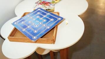 A table with a board game, a cake, and a menu.