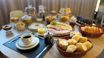 Un bufé de desayuno con diversas opciones de comida, como pasteles, frutas y bebidas.