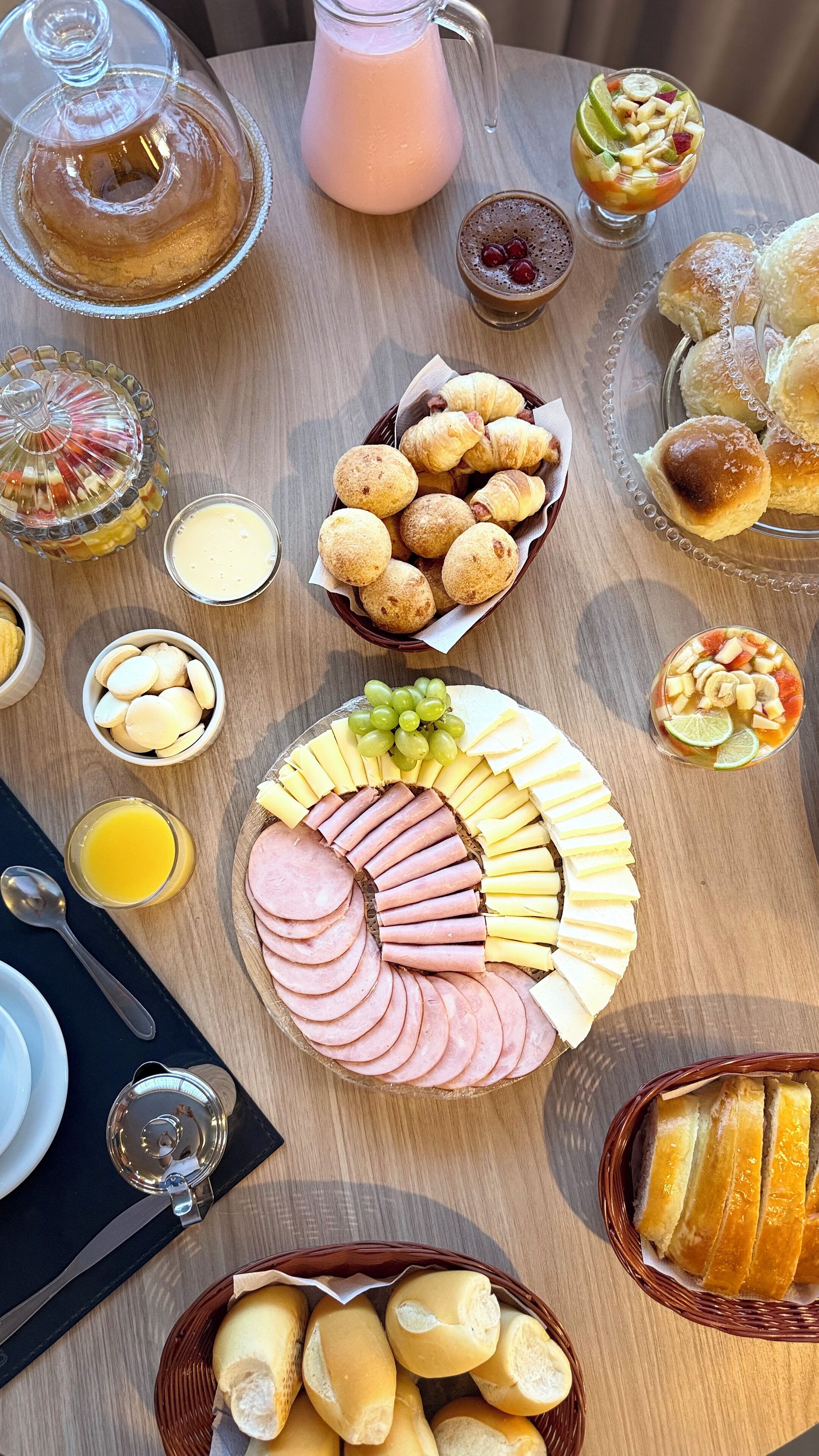 A table with various food items including pastries, cheese, and sliced meats.