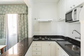 Appartement Duplex, vue ville | Cuisine privée | Réfrigérateur, micro-ondes (sur demande), plaque de cuisson