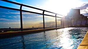 A swimming pool with a view of a bridge and a building in the background. - San Michel Hotel (Taubate)