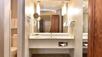A bathroom with a sink, mirror, and toilet.
