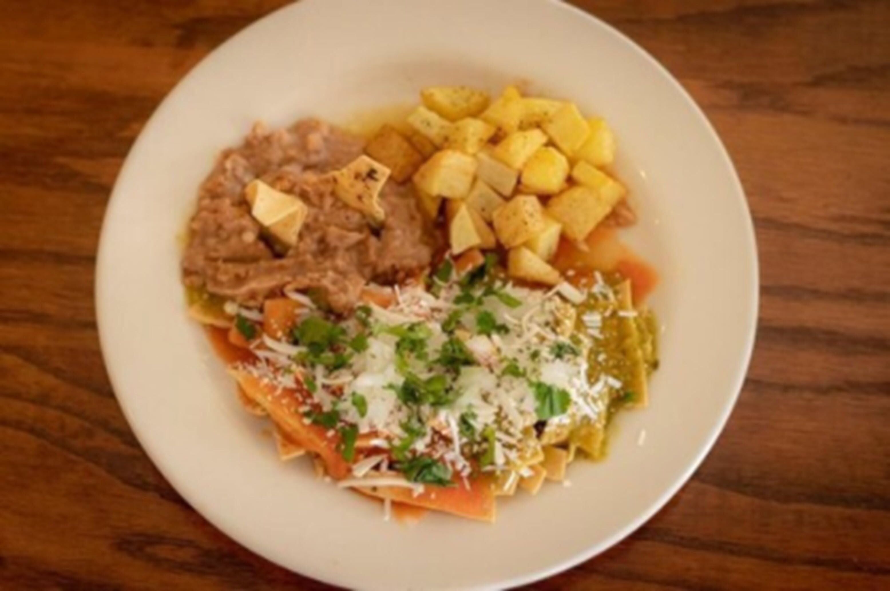 A plate with pasta, a meat dish, and roasted potatoes.