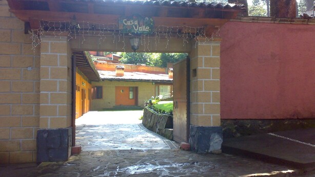 Un sendero de piedra que conduce a un edificio con un cartel que dice "Casa Valle".