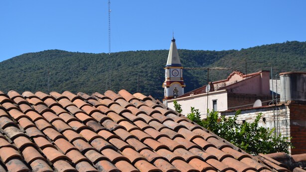 A building with a tiled roof and a clock tower. - Posada Santa Rita (Mascota)