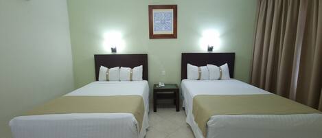 A hotel room with two beds, a nightstand, a framed picture on the wall, and a curtain on the window.