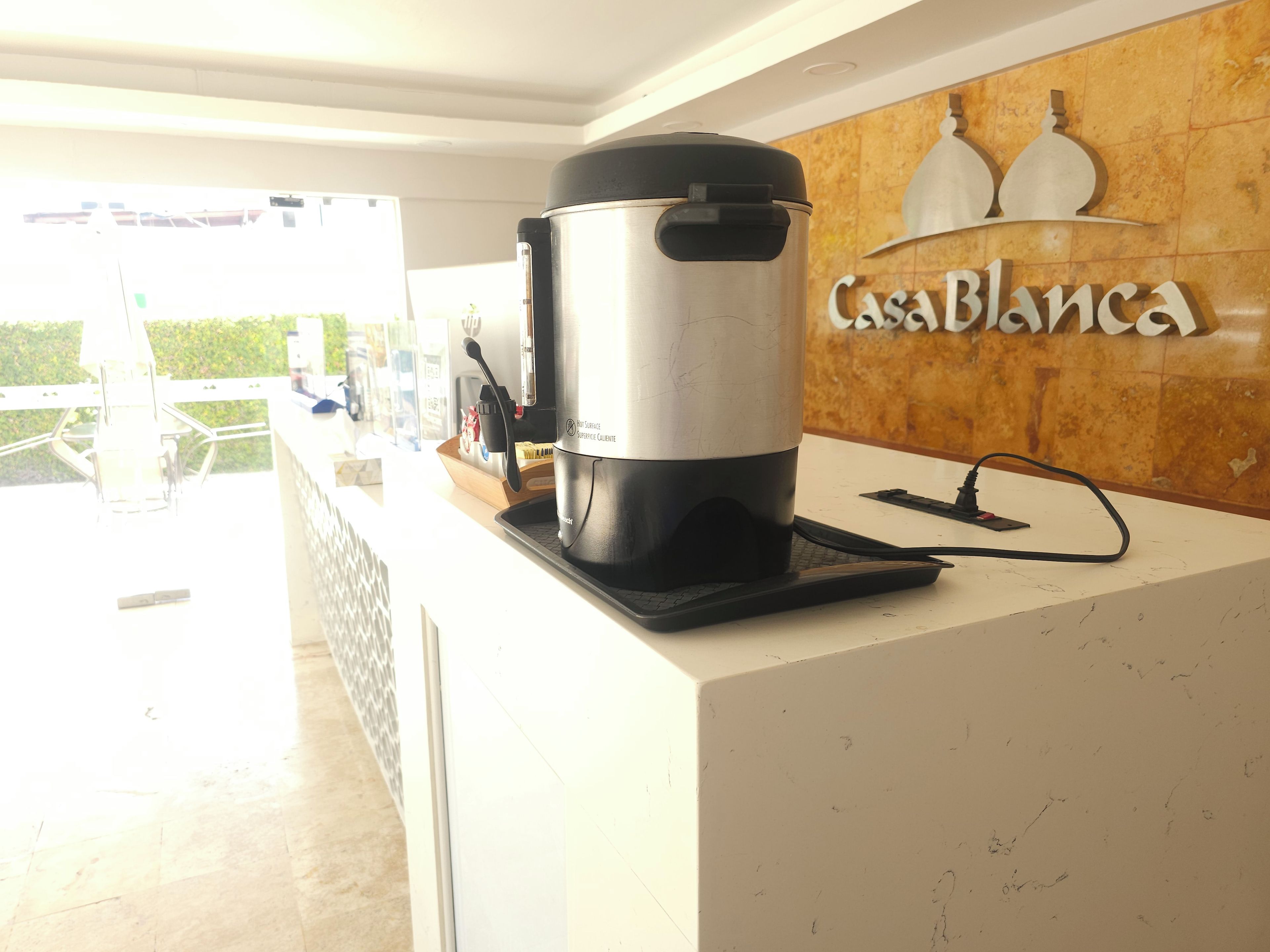 A coffee maker on a countertop with a sign reading "Casa Blanca".