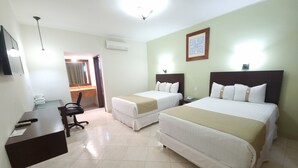 A hotel room with two beds, a desk, a chair, and a bathroom visible through an open door. - Hotel Casa Blanca (Chetumal)