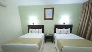 A hotel room with two single beds, a nightstand with a phone, and a framed picture on the wall. - Hotel Casa Blanca (Chetumal)