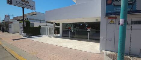 A hotel entrance with a sign for Casa Blanca, a gated entrance, and a warning sign for high voltage.