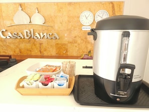 Una encimera de cocina con una cafetera, una bandeja de aperitivos y un cartel que dice 'Casa Blanca'.