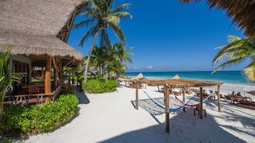 Playa privada, arena blanca, sillas reclinables de playa, sombrillas