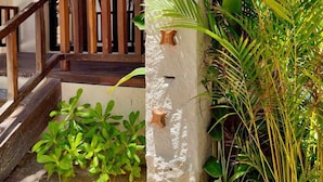 A wooden staircase leading to a covered porch with a white stucco wall, potted plants, and a view of the surrounding area. - Azucar Hotel Tulum    (Tulum)