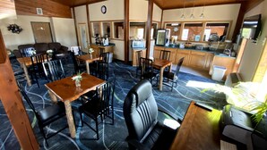 A cozy room with a dining area, kitchen, and a large window.