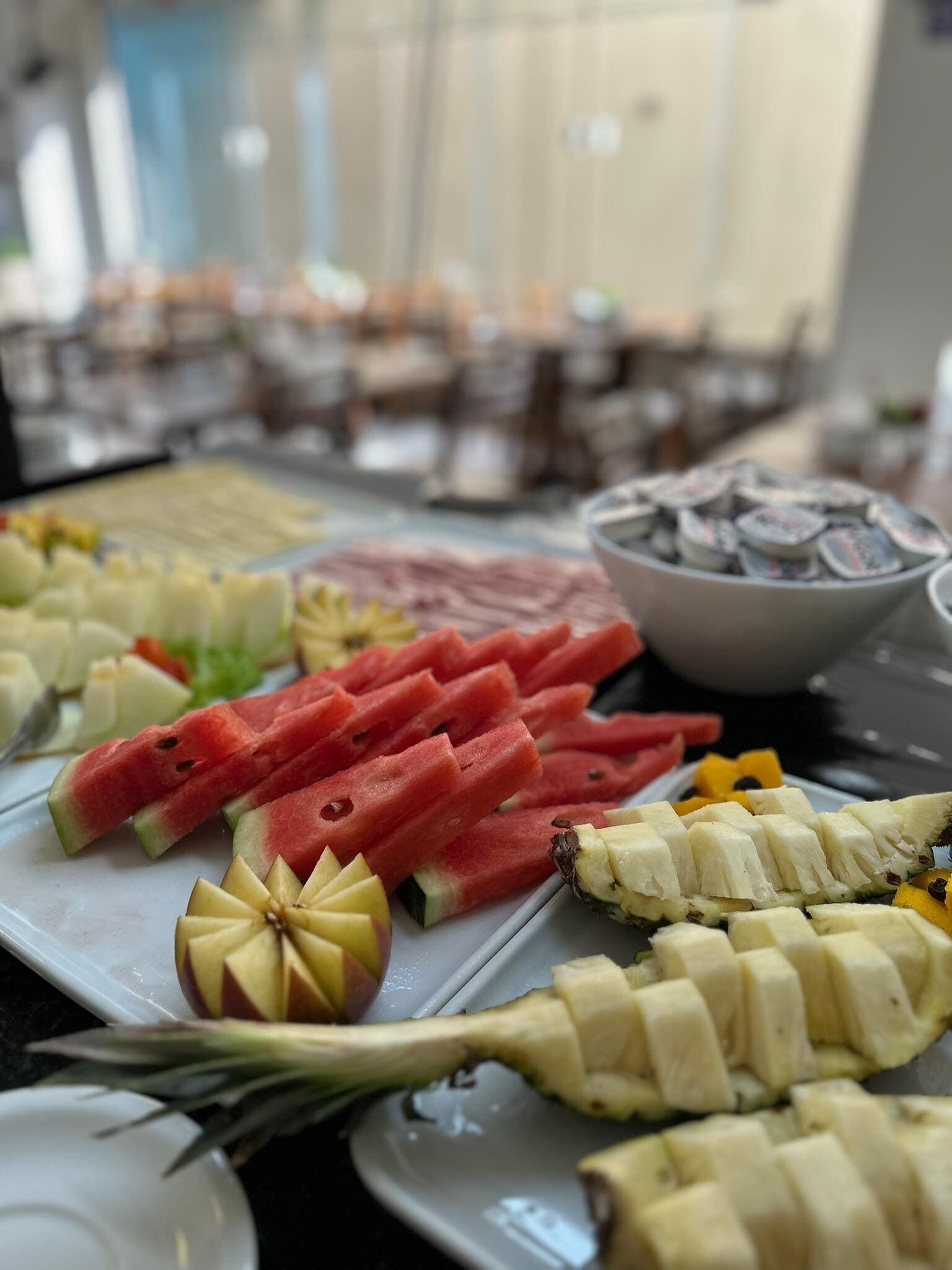 A buffet with various fruits and vegetables, including watermelon, bananas, and apples.