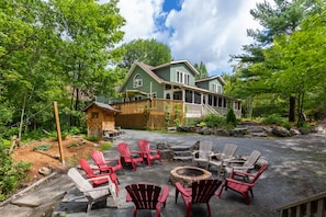A lodge with a covered outdoor seating area, a fire pit, and a wooden deck.