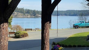 A wooden gazebo with a view of a lake and a parked turquoise truck. - The Latch Inn (Sidney)