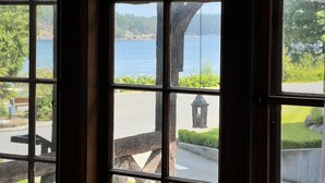 A view through a window with a wooden structure outside, including a swing and a lantern. - The Latch Inn (Sidney)