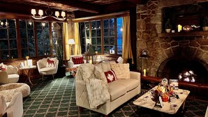 A cozy living room with a fireplace, a sofa, and a table set for dining. - The Latch Inn (Sidney)