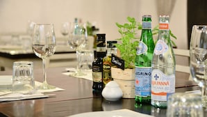A dining table set with wine glasses, bottles of wine, and a salt and pepper shaker. - Unic Design Hotel - Near Mamitas Beach Club (Playa del Carmen)