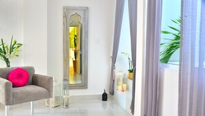 A modern living room with a grey sofa, a large mirror, and a potted plant. - Unic Design Hotel - Near Mamitas Beach Club (Playa del Carmen)