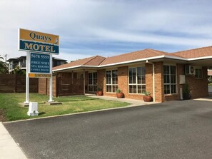 A motel with a signboard advertising free WiFi, spa rooms, and family rooms. - Quays Motel San Remo (San Remo)
