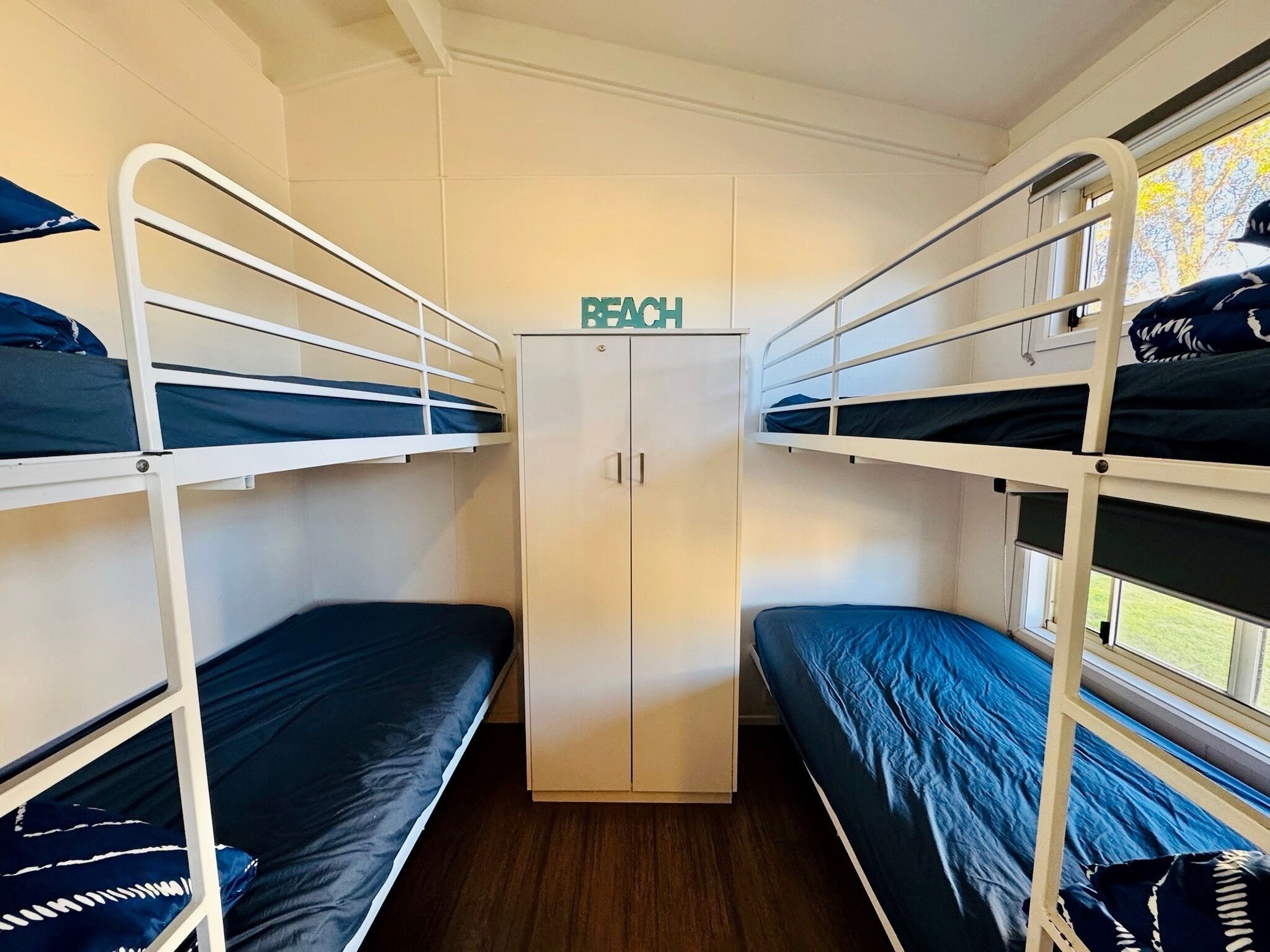 A train compartment with bunk beds, a wardrobe, and a sign indicating the compartment number.