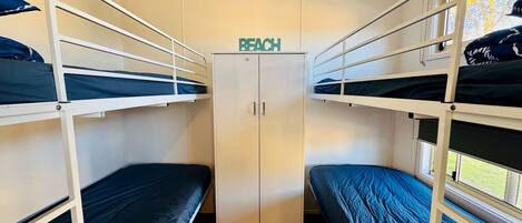 A train compartment with bunk beds, a wardrobe, and a sign indicating the compartment number.