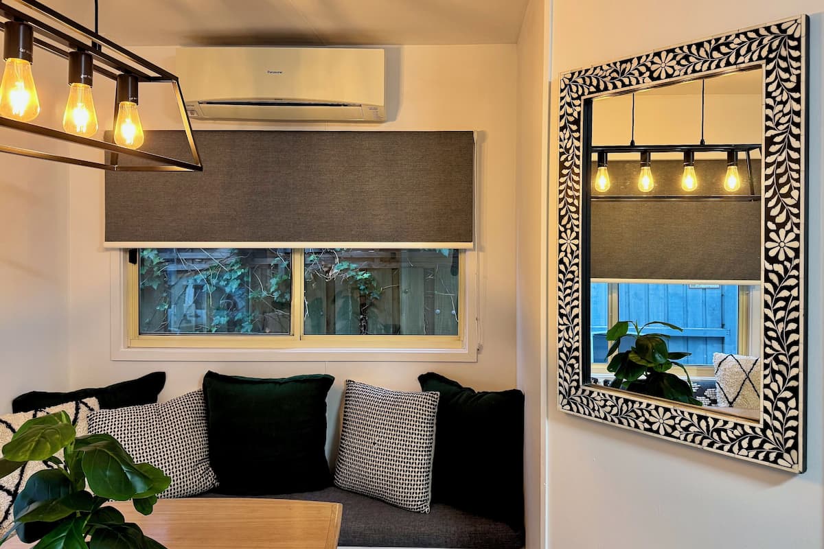 A modern living room with a sofa, a table, and a large decorative mirror.
