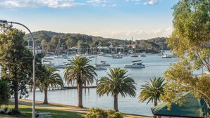 A marina with boats, palm trees, and a gazebo.
