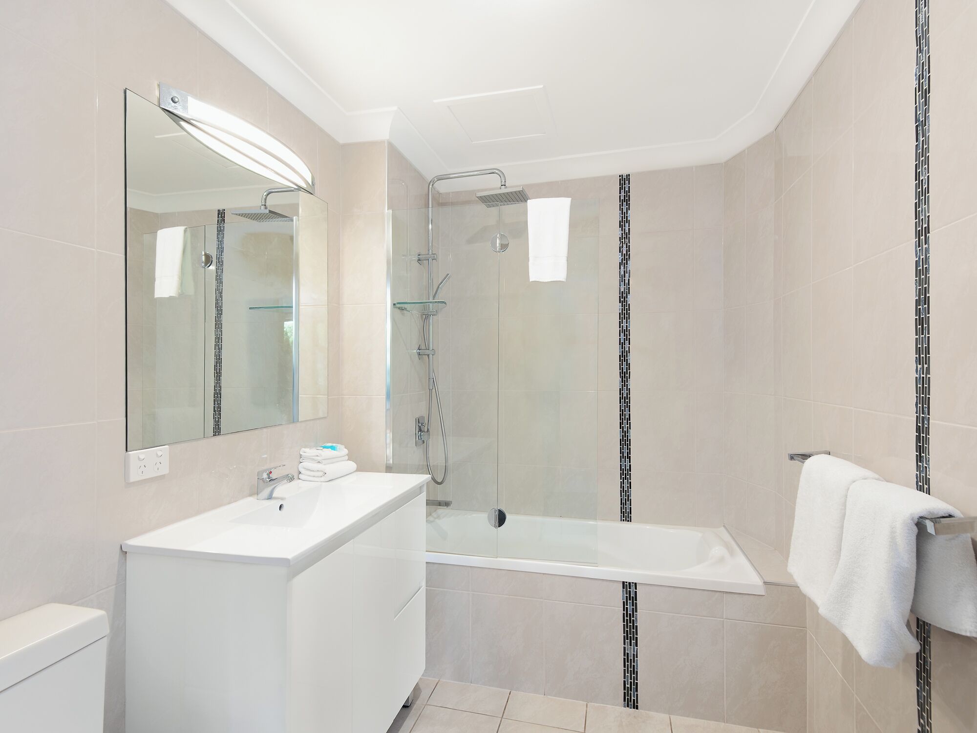 A modern bathroom with a glass-enclosed shower, a white sink, and a bathtub.