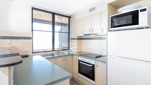A modern kitchen with a built-in oven, microwave, and a large window providing natural light.