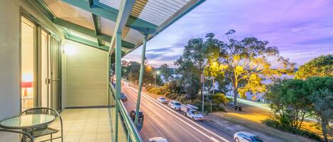A balcony with a view of a road and trees.