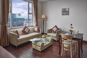 A modern living room with a sofa, armchair, coffee table, and dining table.
