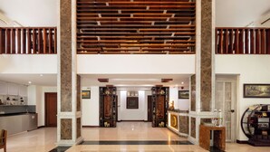 A spacious lobby with a high ceiling, a central staircase, and a reception desk. - Phnom Penh Katari Hotel (Phnom Penh)