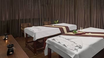 Relax in this serene space with two massage tables, a wooden bench, and a small plant.